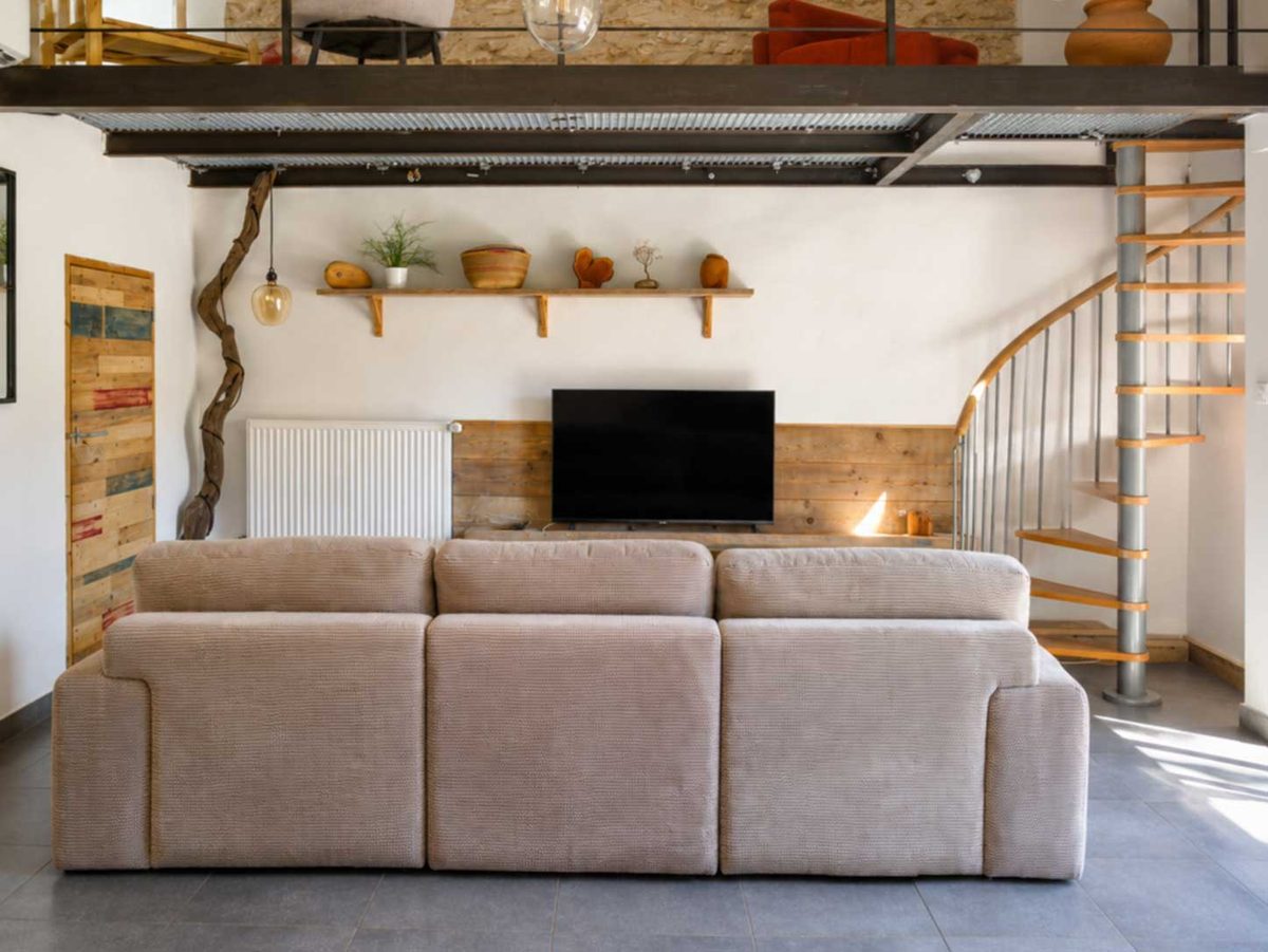 Salon avec vue sur la mezzanine et escalier hélicoïdal